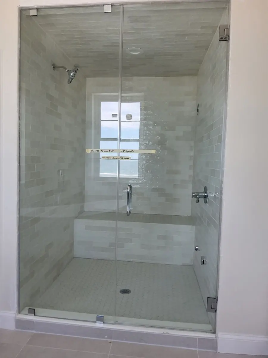 Frameless steam shower enclosure